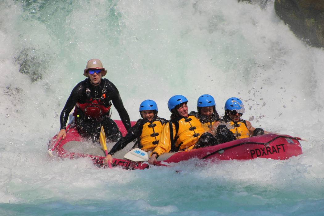 A raft punching out of the whitewater at the base of Husum Falls